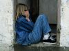 lonely girl sitting on a doorway